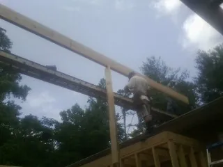 Carpenter setting a ridge beam over a new addition frame — Ice Dam Removal by Roofing Brothers in Talbott
