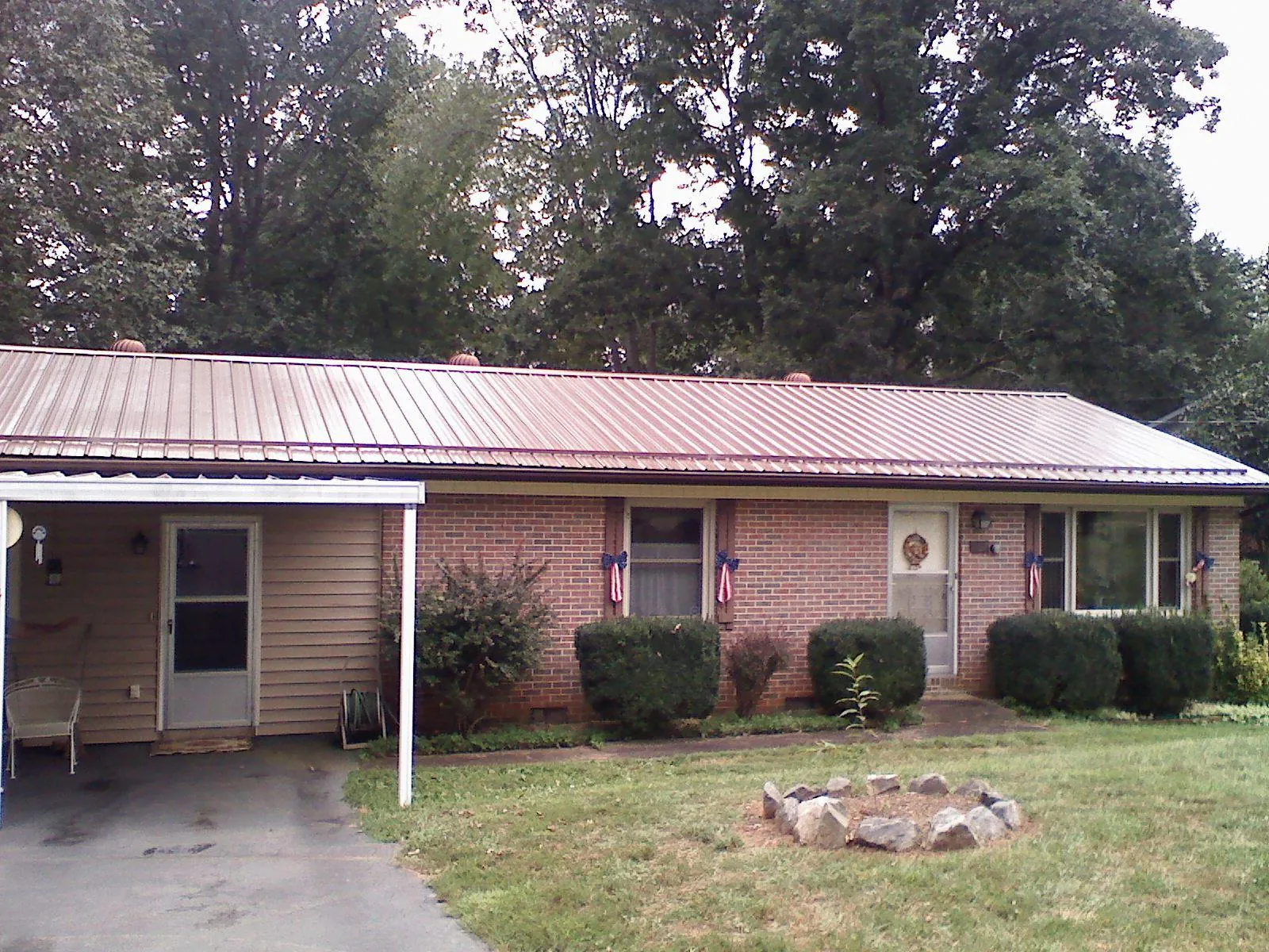 Bronze metal roof and carport on a brick ranch home — Roof Repair work by our crew in Talbott